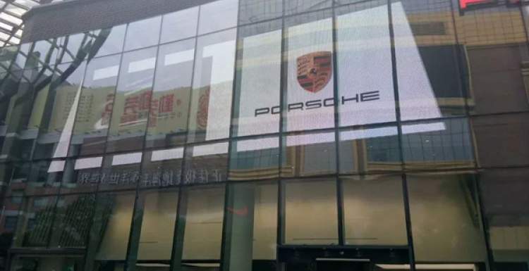 Foto: Gläserne Außenfront eines Porsche-Stores mit großer LED-Wand;...