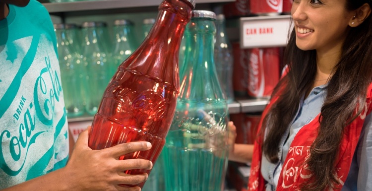 Zwei Leute mit großen farbigen Coca Cola-Flaschen; copyright: The Coca-Cola...