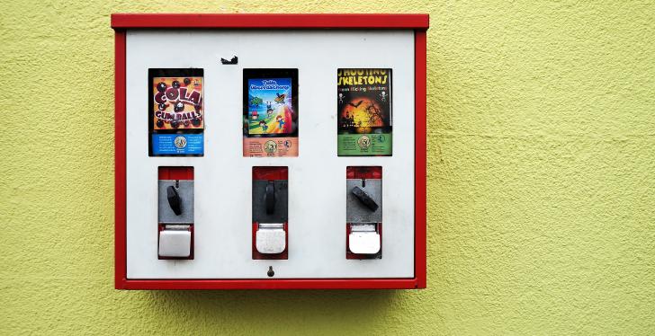 Ein Kaugummiautomat an einer gelben Wand; Photo by Dmitri Popov on Unsplash...