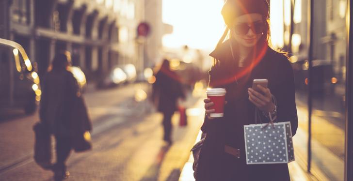 Frau auf der Straße mit Smartphone in der Hand