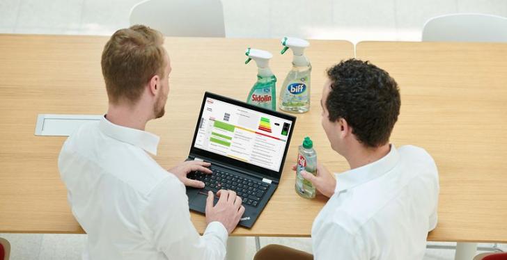 Zwei Männer  in weißen Hemden schauen gemeinsam auf einen Laptop - von hinten...