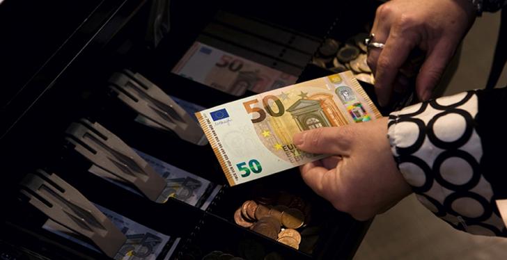 Geldkasse, Frau hält 50 Euroschein in den Händen