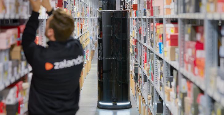Stelen-Roboter im Lager im Vordergrund ein Mann