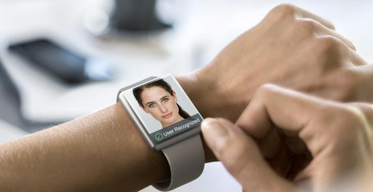 Intelligente Uhr an einem Arm mit einem menschlichen Gesicht auf dem Display;...