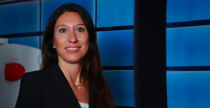 eine dunkelhaarige Frau vor einem blauen Hintergrund...