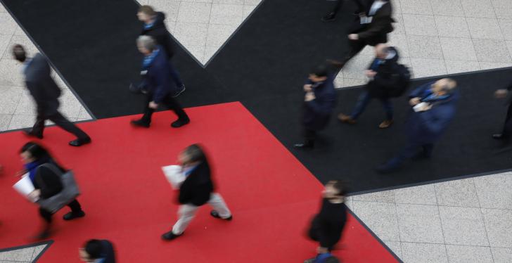 Das große Euroshop-Logo, ein rot-schwarzer Stern, auf dem Boden. Menschen...
