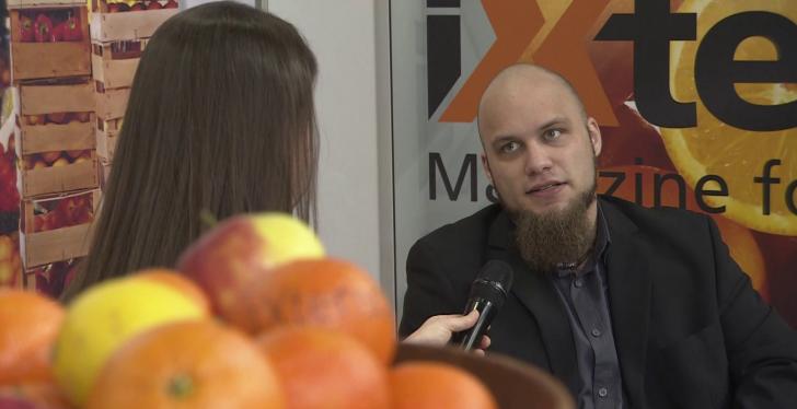 Orangen unscharf im Vordergrund, im Hintergrund ein Mann, der interviewt wird...