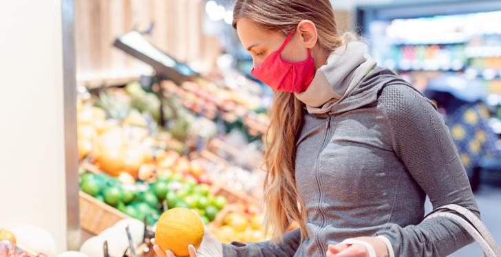 Frau mit Mundschutz in Gemüseabteilung im Supermarkt...