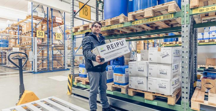Ein Mitarbeiter in einem Lager trägt ein Paket