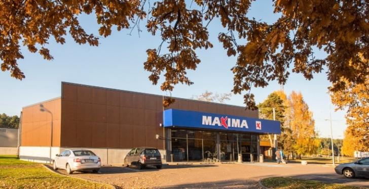 Eine Supermarktfiliale von außen zwischen herbstlich gefärbten Bäumen...