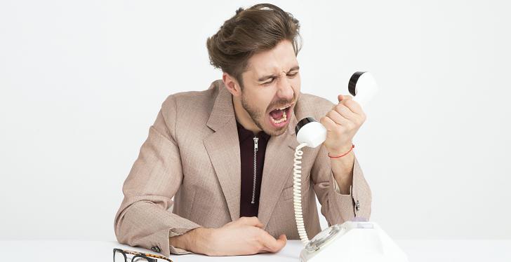 Ein wütender mann schreit in ein weißes Telefon