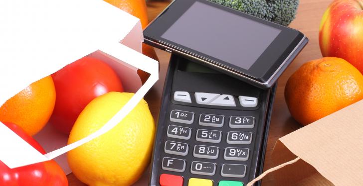 Smartphone mit NFC Funktion liegt auf einem Bezahlterminal...