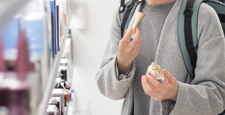 Frau in Parfümerie hält Produkt in ihrer Hand