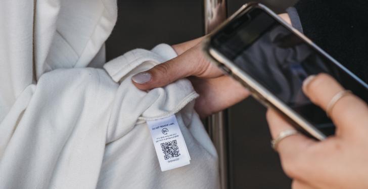 Smartphone scannt QR-Code auf Etikett eines Kleidungsstücks...
