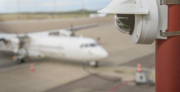 Eine Überwachungskamera außen an einem gebäude an einem Flughafenrollfeld...