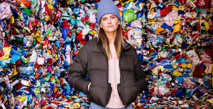 Influencerin Melisa Dobric vor einer Wand aus Plastikabfällen...