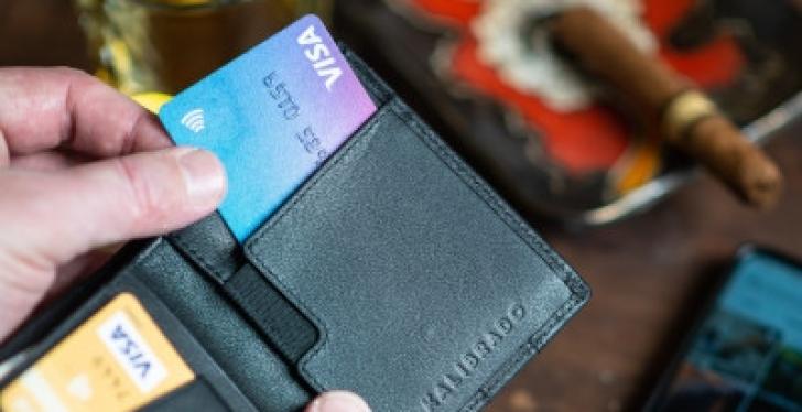Eine Person nimmt eine Kreditkarte aus der Geldbörse...