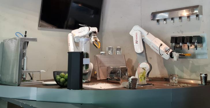 Zwei Roboterarme mixen Cocktails