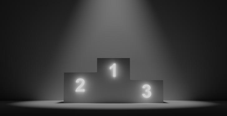 Ein Podium mit drei Plätzen erleuchtet vor dunklem Hintergrund; copyright:...