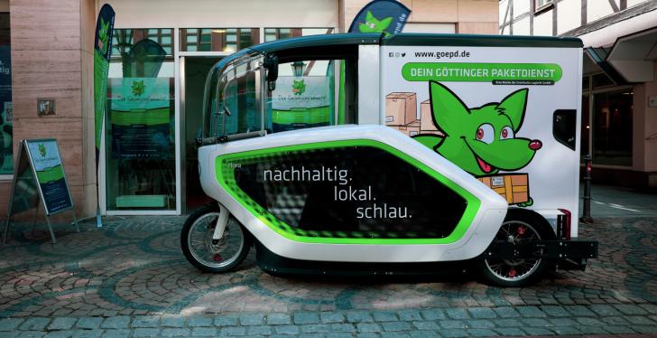Ein emissionsfreies Lieferfahrzeug mit einem aufgemalten grünen Fuchs steht...