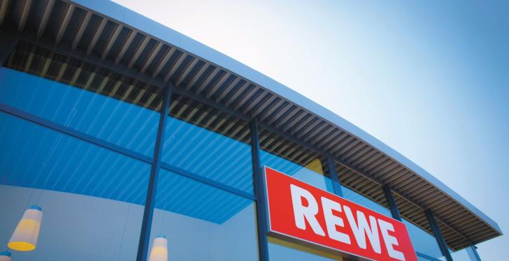 Front eines REWE- Stores mit rot weißes REWE-Logo