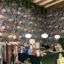 Blick in den vorderen Teil des Ladens auf die Kasse mit Flamingo-Tapete im...