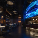 Ein Restaurant mit einem blauen LED-Bildschirm über der Bar...