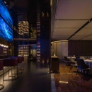 Ein Restaurant mit einem blauen LED-Bildschirm über der Bar...