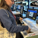 Person faltet den Versandkarton zusammen und schließt ihn nach dem Verpacken...