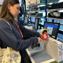 Person verschließt den Versandkarton sicher mit Packband an der Packstation....