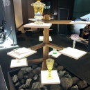 Mehrstufiges Display mit beleuchteten Podesten, auf denen Glasgefäße und eine...