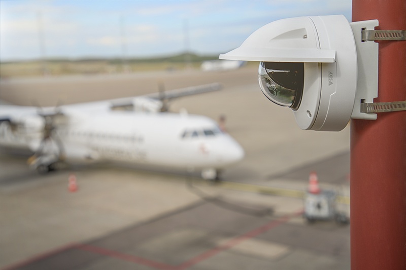 Eine Überwachungskamera außen an einem gebäude an einem Flughafenrollfeld...