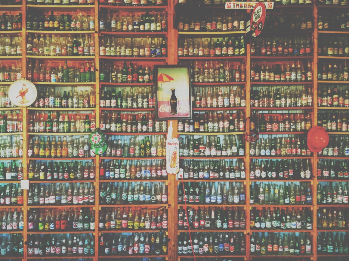 Ein Holzregal in einem Laden komplett gefüllt mit Flaschen von oben bis unten...