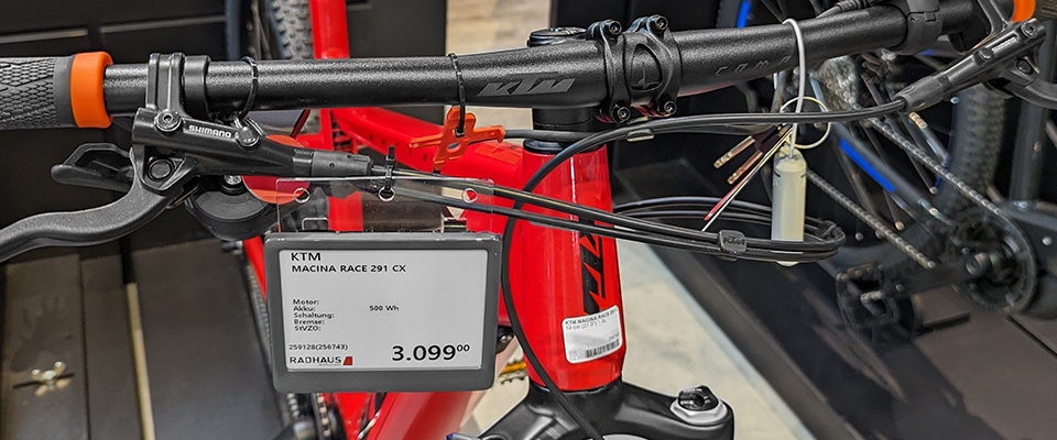 Ein elektronisches Regaletikett hängt an einem roten Fahrrad...