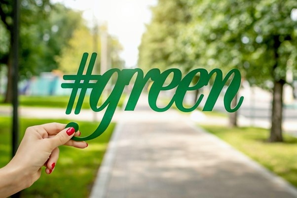Hand die Hashtag mit dem Schriftzug Green in die Höhe hält....