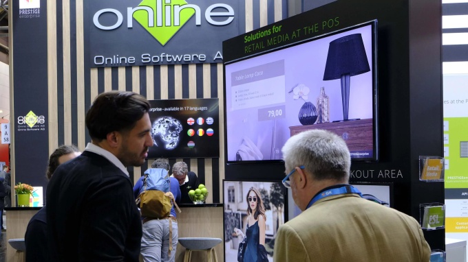 2 Personen unterhalten sich auf einem Messe-Stand.