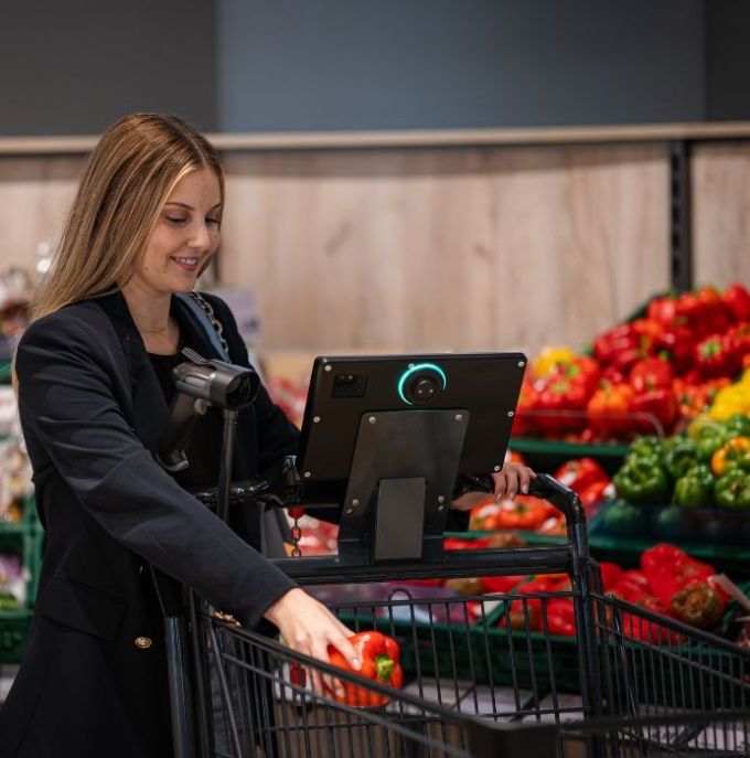 Frau mit Smart Shoper im Supermarkt