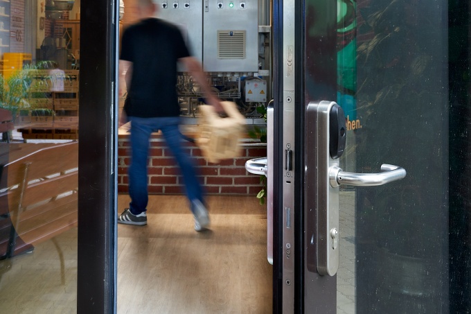 Offene Glastür, im Hintergrund Mann der geht.