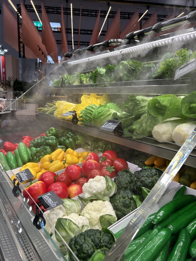 Kühlregale mit feinem Sprühnebel auf frisch aussehendes Gemüse....