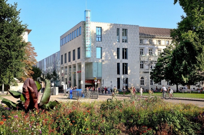 Einkaufszentrum von außen mit Wiese im Vordergrund...