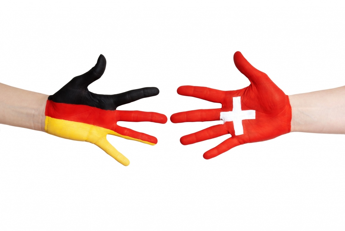 Foto: zwei Hände, eine mit deutscher Nationalflagge bemalt, die andere mit...
