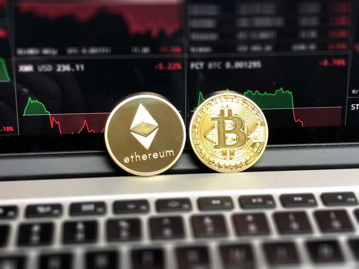 Foto: Zwei Münzen der Kryptowährungen Bitcoin und Ethereum auf einer...