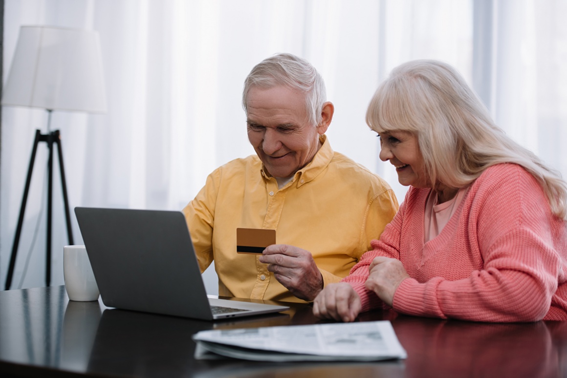 Zwei Senioren - Mann und Frau - sitzen vor dem Laptop und shoppen online...