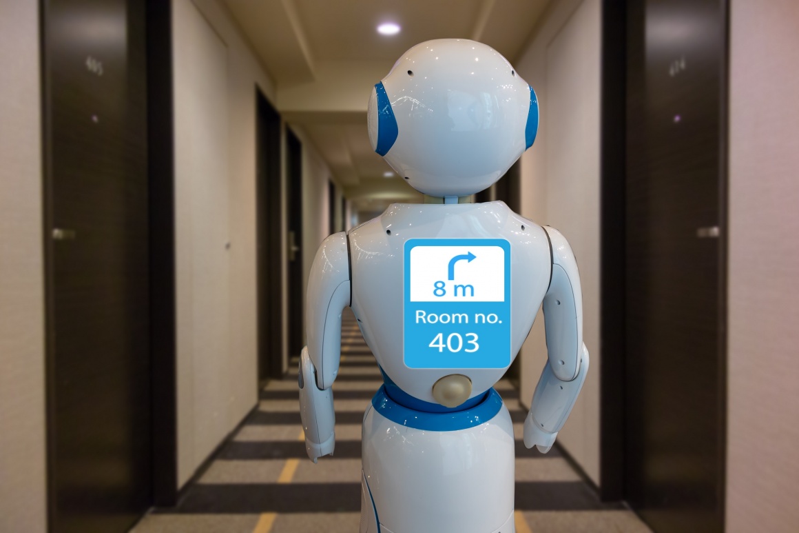 Ein weißer humanoider Roboter mit Bildschirm im Gang eines Hotels...
