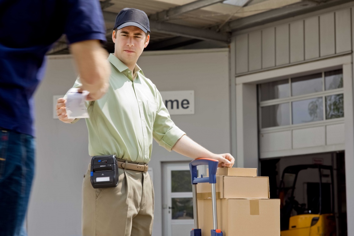 Ein Logistikmitarbeiter überreicht einen Beleg