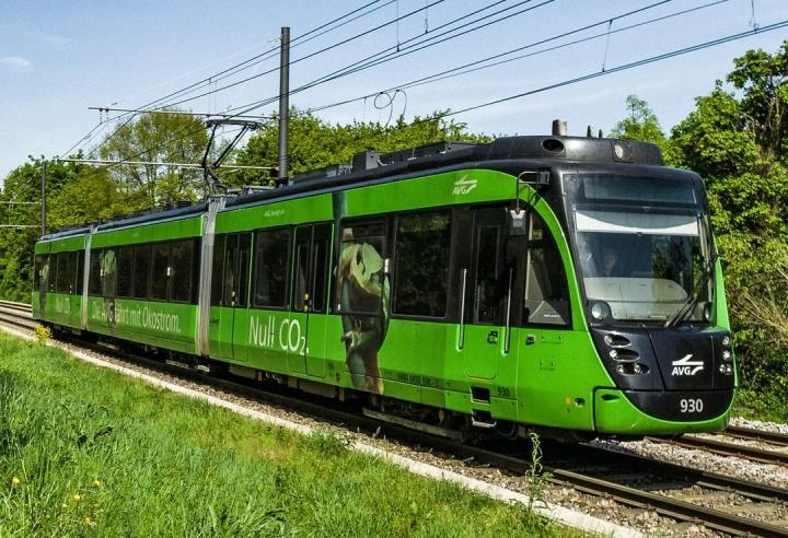Eine grüne Straßenbahn der Albtal-Verkehrs-Gesellschaft im Grünen...