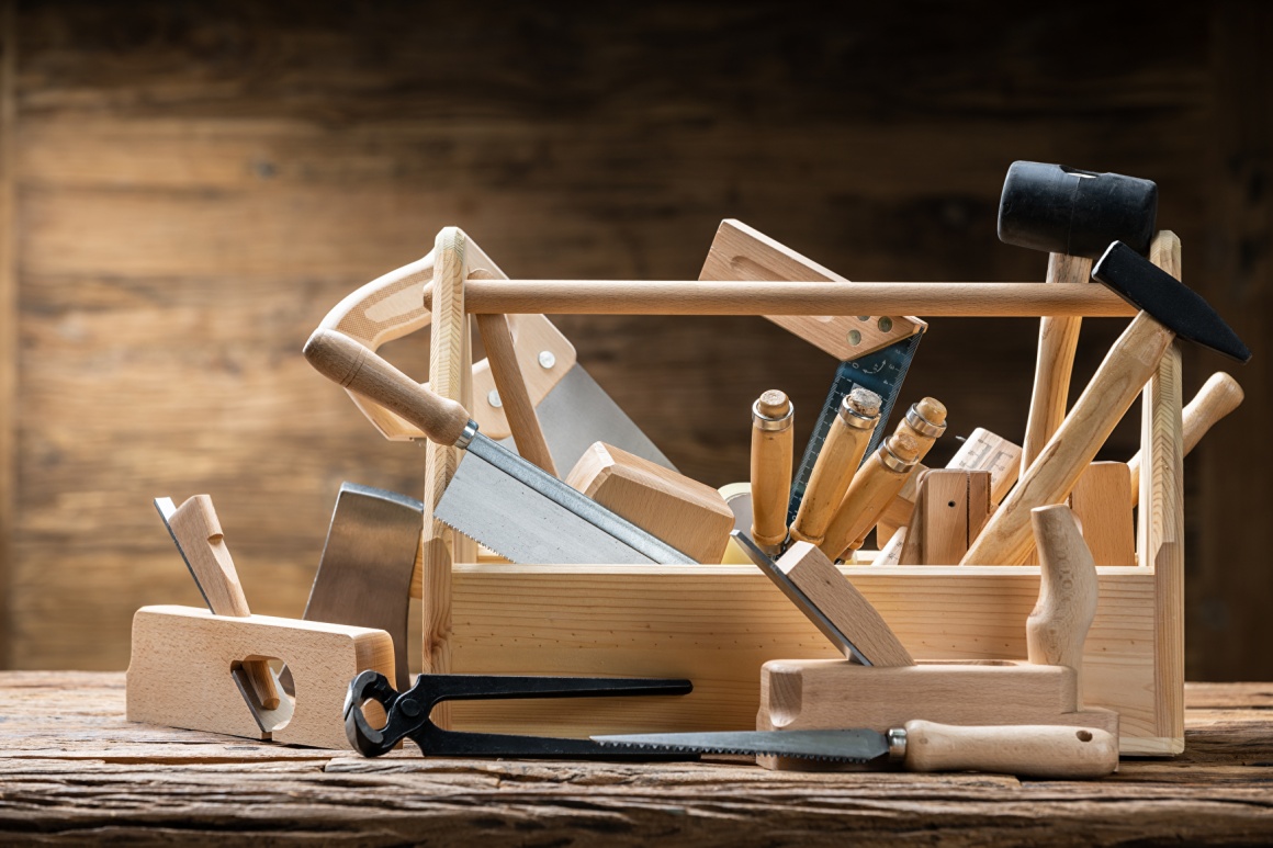 Offener Werkzeugkasten aus Holz mit hölzernen Werkzeugen...