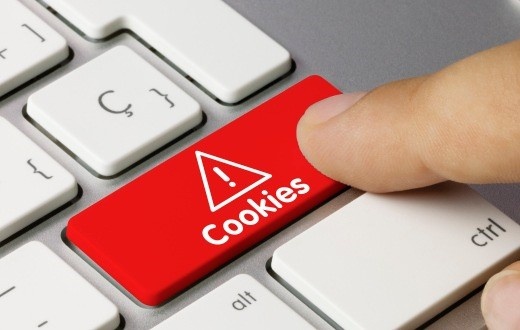 Finger tippt auf rote Keyboard-Taste mit der Aufschrift Cookies unter einem...
